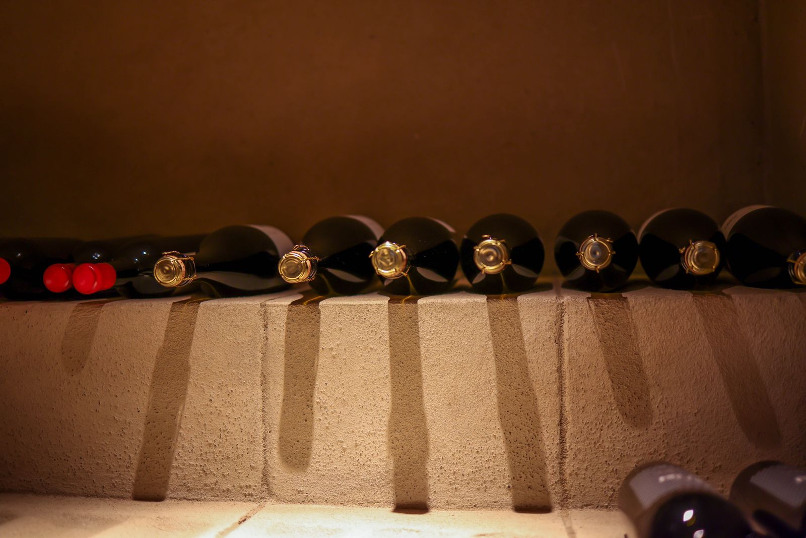 Vintage bottles resting in the dimly lit cellar beneath the dining room