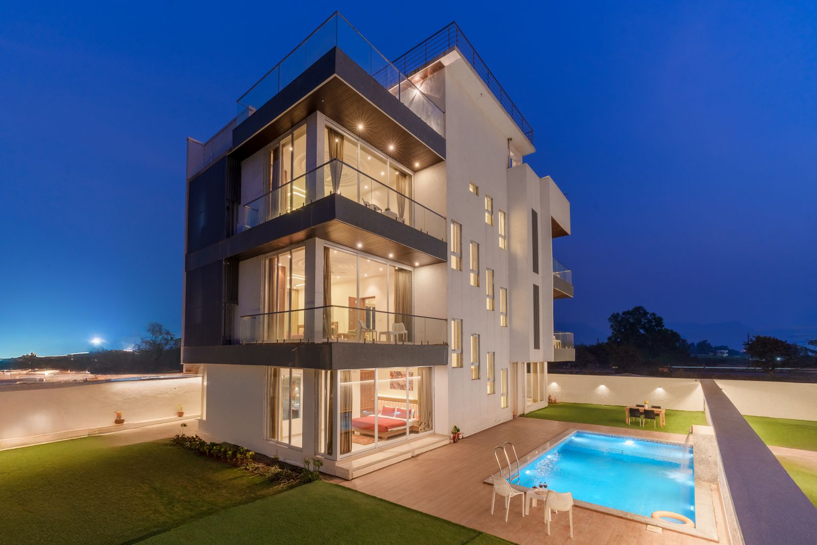 Alcove Ridge — a contemporary home with a cantilevered upper floor and illuminated pool at twilight