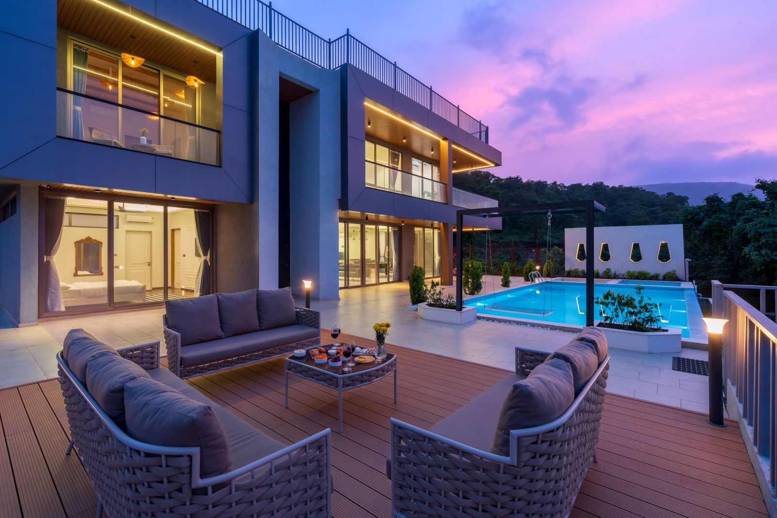 The Meridian — a modern stone villa with terraced outdoor seating and a pool, photographed at sunset
